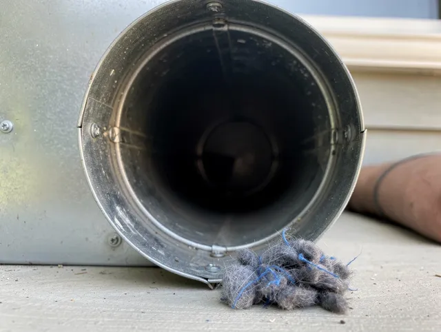 Highland Dryer Vent Cleaning technician using specialized equipment to clear severe dryer vent blockage in Highland